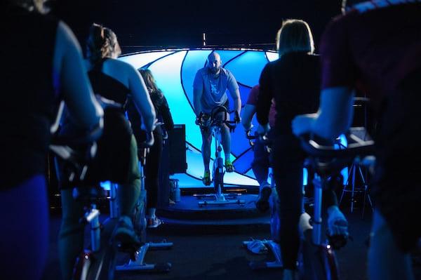 A teacher leads students in a spinning class.